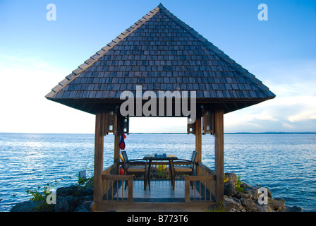 Bordo d'acqua rifugio al tramonto, Shangri-La Island Resort & Spa, Mactan Island, Cebu, Visayas, Filippine Foto Stock