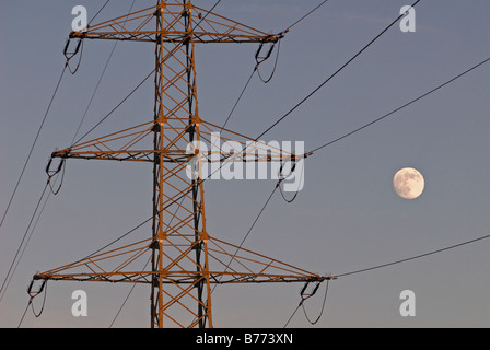 Di elettricità ad alta tensione pilone con full MOON RISING, Leichlingen, Renania settentrionale-Vestfalia (Germania). Foto Stock