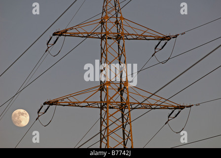 Di elettricità ad alta tensione pilone con full MOON RISING, Leichlingen, Renania settentrionale-Vestfalia (Germania). Foto Stock