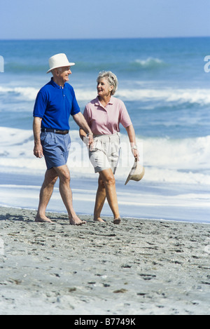 Seniors rilassante insieme, camminando sulla spiaggia, Miami Foto Stock