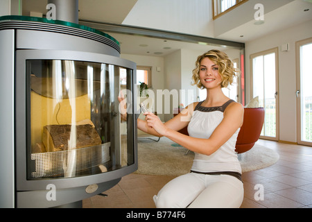 Frau macht Feuer in einem Ofen, donna rende gli incendi in un forno Foto Stock