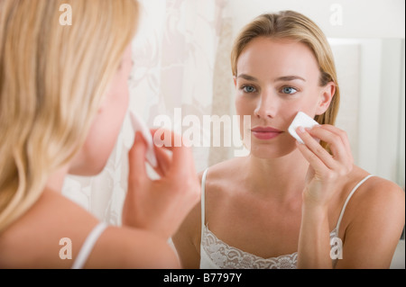Donna applicando Specchio bagno Foto Stock