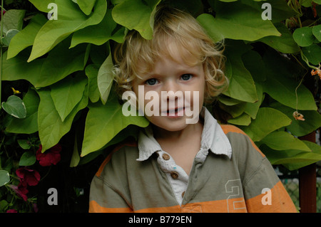 Un bel po' di ragazzo in sua madre garden Foto Stock