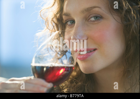 Close up ritratto di donna annusare il vino rosso Foto Stock