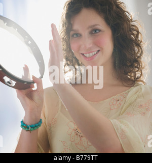 Close up della donna che gioca il tamburello Foto Stock