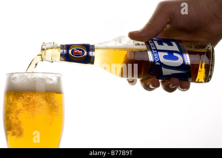 Promuove il ghiaccio birra che viene versata da una bottiglia in un bicchiere. Foto Stock