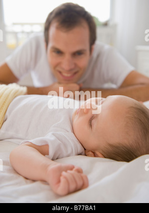 Padre guardando baby figlio dormire Foto Stock