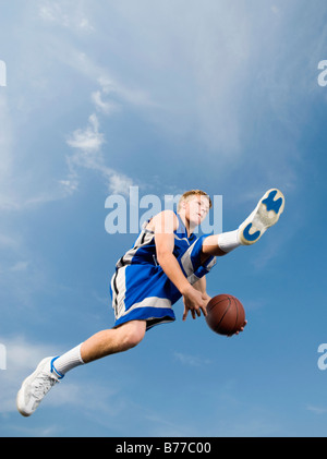 Teenage giocatore di basket mid-air basket Foto Stock