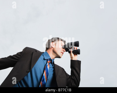 Imprenditore cerca attraverso il binocolo Foto Stock