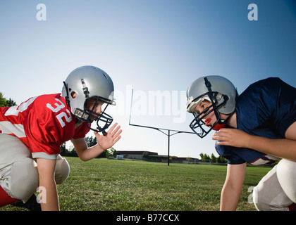 Opposti i giocatori di calcio rivolto verso la linea di scrimmage Foto Stock