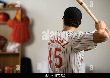 Giocatore di baseball praticando swing Locker room Foto Stock