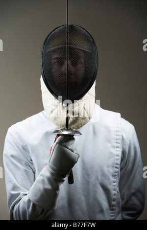 Ritratto di fencer uniforme e maschera holding lamina di scherma Foto Stock