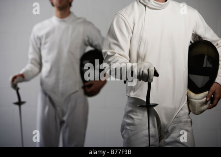 Ritratto di schermitori holding maschere e lamine di scherma Foto Stock