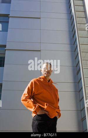 Ritratto di giovane uomo in piedi davanti a highrise Foto Stock