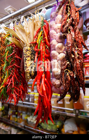 Peperoncini essiccati e aglio appeso su uno stallo presso il mercato coperto appena fuori La Rambla high street a Barcellona. Foto Stock