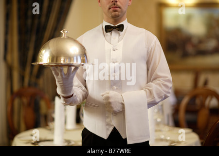 Cameriere in possesso di una cloche in un ristorante Foto Stock