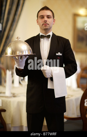 Cameriere in possesso di una cloche in un ristorante Foto Stock