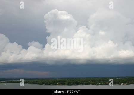 Alta, il bianco delle nuvole contrasto ombre scure in seguito in questa foto panoramica di un avanzamento tempesta davanti su un ingresso del lago Ontario Foto Stock