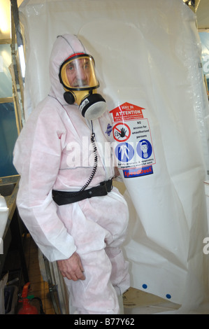 Uomo vestito in pieno gli indumenti di protezione per lavorare in un ambiente sicuro per rimuovere amianto Exeter Foto Stock