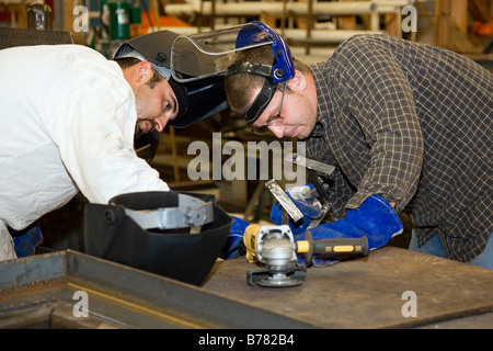 Due saldatrici a lavorare insieme su un difficile lavoro di metallo progetto autentico e accurata rappresentazione del contenuto Foto Stock