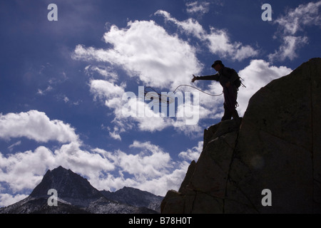 Silhouette di un uomo con una corda di arrampicata su una scogliera mentre la palestra di roccia nei pressi di South Lake in Sierra Mountains della California Foto Stock