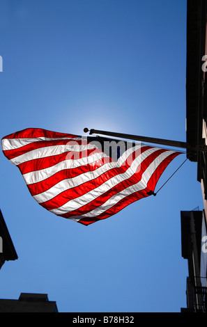 Fluente bandiera degli Stati Uniti d'America, retroilluminazione contro il cielo blu, New York City, Stati Uniti d'America, America del Nord Foto Stock