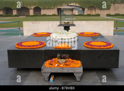 Monumento di pietra, Samādhi, con offerte di fiori a Mohandas Karamchand Gandhi, il Mahatma Gandhi, al Raj Ghat. Delhi, India Foto Stock