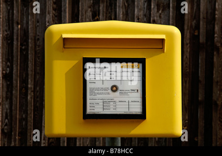 Postbox giallo nella parte anteriore di un fienile ringhiera Thuisbrunn, Alta Franconia, Baviera, Germania, Europa Foto Stock