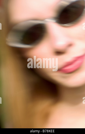 Giovane donna,indossando occhiali da sole,in posa. Modello rilasciato. Foto Stock