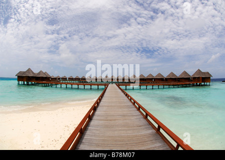 Molo che conduce al water bungalows in Baros Resort, Maldive, Oceano Indiano Foto Stock