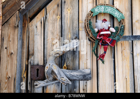 Ghirlanda di Natale decorazione su wilderness lodge porta in Saariselkae regione sciistica, Ivalo, Lapponia, Finlandia, Europa Foto Stock