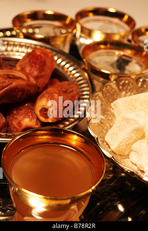 Una tazza di tradizionale caffè verde (ghawa) con delizie turche (raha haloum) e le date su un vassoio d'argento Foto Stock