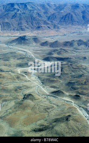 Una veduta aerea di un fiume e una strada che attraversa una valle in una regione montuosa area nel deserto vicino a Swakopmund Foto Stock