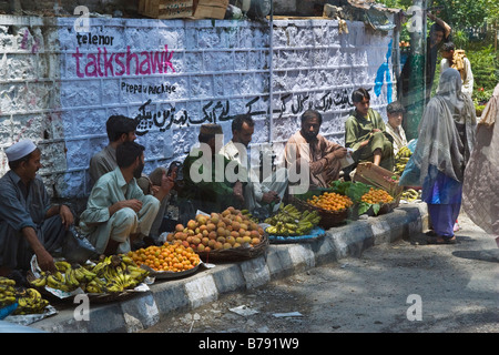 Gli uomini per la vendita di frutta lungo il lato della strada a Islamabad in Pakistan Foto Stock