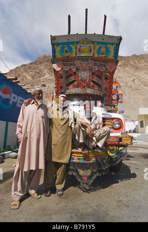 Tre Pakistani driver del carrello e un ornato trucke lungo la Karakoram Highway in Pakistan Foto Stock