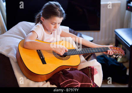 Ragazza giovane di suonare una chitarra Foto Stock