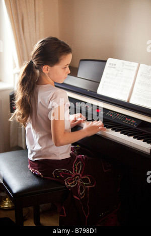 Ragazza giovane la riproduzione di una tastiera per pianoforte elettronico Foto Stock