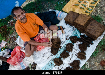 L'uomo la vendita di tabacco nel mercato Kapan, Timor Ovest, Indonesia Foto Stock