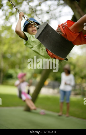 6 anno vecchio ragazzo su uno swing Foto Stock