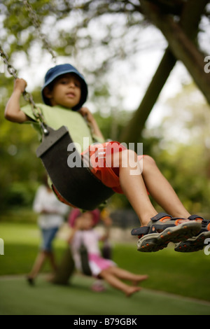 6 anno vecchio ragazzo su uno swing Foto Stock