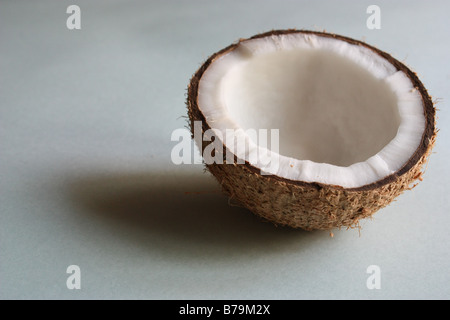 Una metà di noce di cocco in sfondo bianco Foto Stock