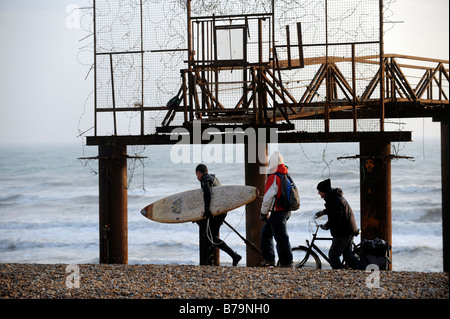 Un surfista porta la sua tavola oltre il West Pier a Brighton - 2009 Foto Stock