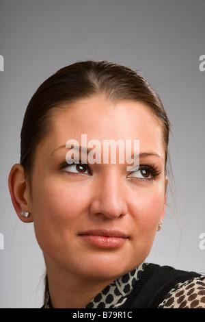 Attraente giovane donna che guarda lontano dalla fotocamera Foto Stock