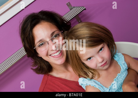 Madre tenendo la sua giovane figlia sul suo giro modello rilasciato Foto Stock