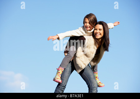 Madre di dare a sua figlia una Piggy Back Ride Foto Stock