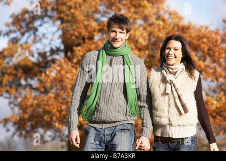 Coppia giovane passeggiate nel parco tenendo le mani Foto Stock