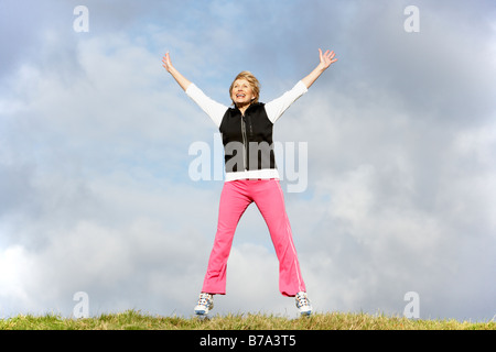 Senior donna salta in aria Foto Stock