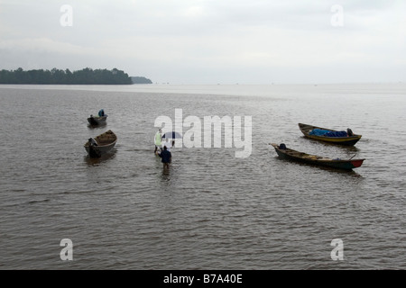 Passeggeri trampolieri fuori per piroga che li traghetto per il villaggio attraverso Wourri estuario del fiume nei pressi di Douala Camerun Africa occidentale Foto Stock