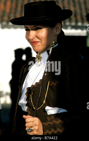 Una Donna vestita di decorativo abbigliamento equestre all annuale Golegã horse festival in Portogallo Foto Stock