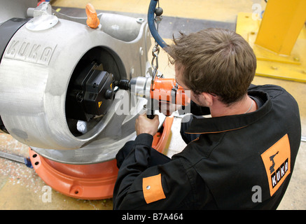 La meccatronica apprendista presso il robot nella produzione del KUKA Roboter GmbH, responsabile del dipartimento di robotica della IWKA UN Foto Stock